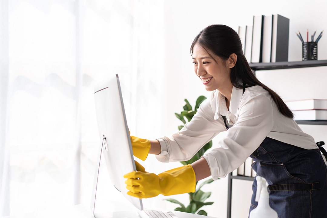 Maid in apron wearing gloves to using microfiber fabric to