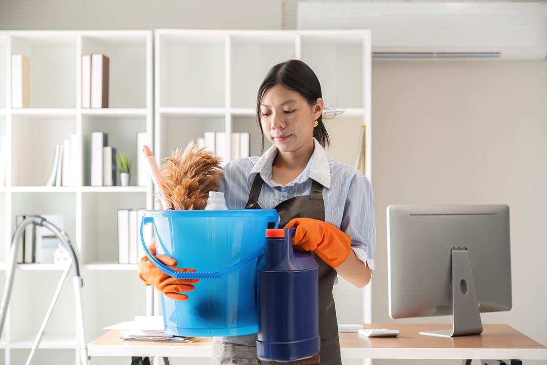 Young woman cleaning to disinfect computer and equipment on office table Cleaning staff or maid cleaning the office